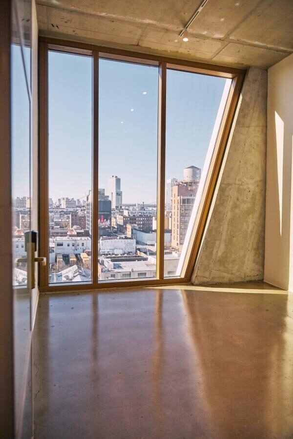 An empty raw office wrapped in the tower's signature full-height angular glazing
